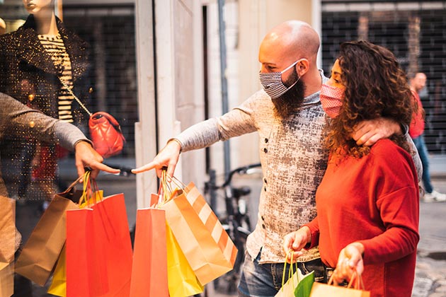 Consumidores carregando sacolas de compra. Veja nossas dicas para vender mais no dia do cliente!