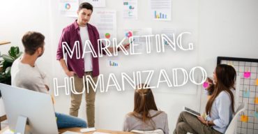 Grupo em reunião com apresentação de dados e gráficos, representando o conceito de marketing humanizado.
