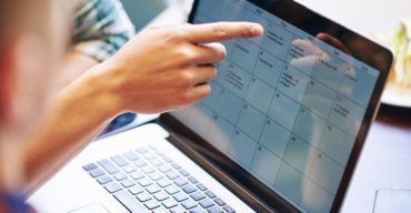 Aprenda como montar um calendário de conteúdo para as redes Pessoa organiza datas e publicações em um calendário de conteúdo no notebook.
