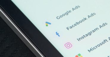 Entenda as diferenças entre Google Ads e Meta Ads com a Trii! Tela de smartphone exibe menus de ferramentas do Google Ads e Meta Ads.