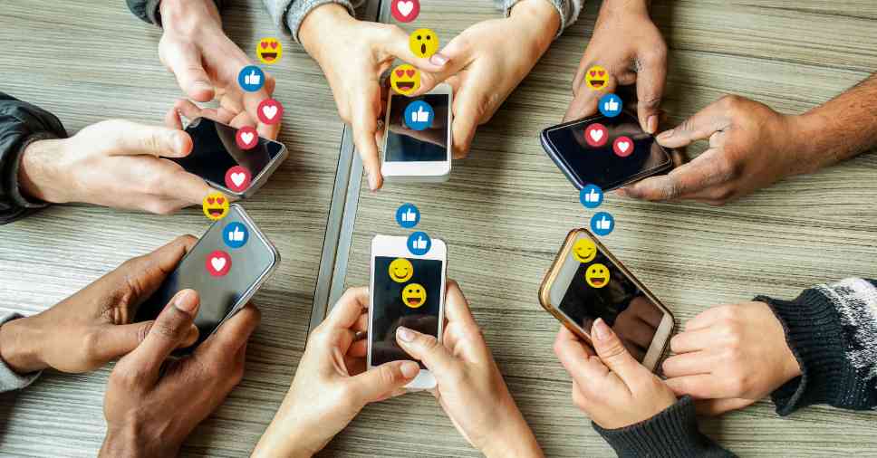 Pessoas reunidas e utilizando celulares, destacando a importância do calendário editorial para redes sociais.
