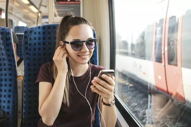 mulher ouvindo podcast no ônibus